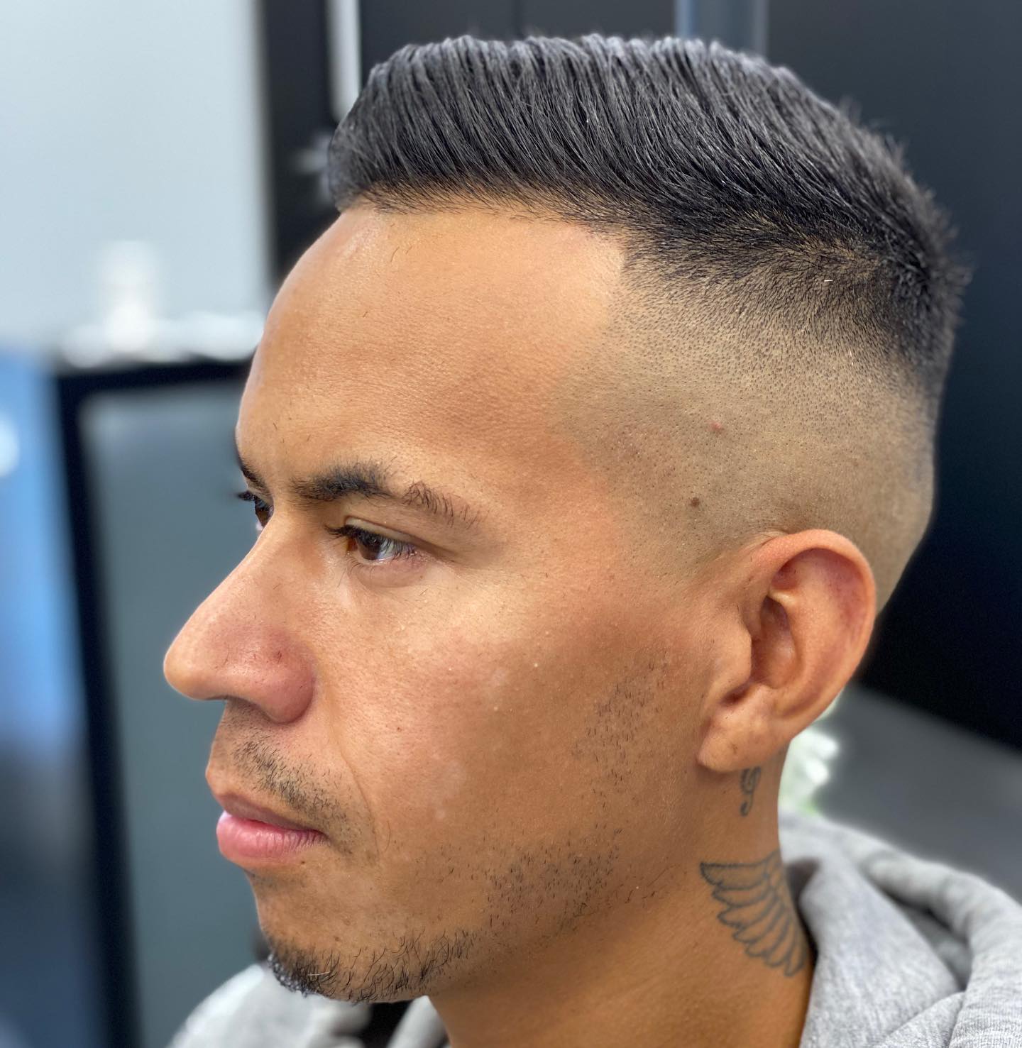 Man in profiel met een skin fade en een opgestylde bovenkant