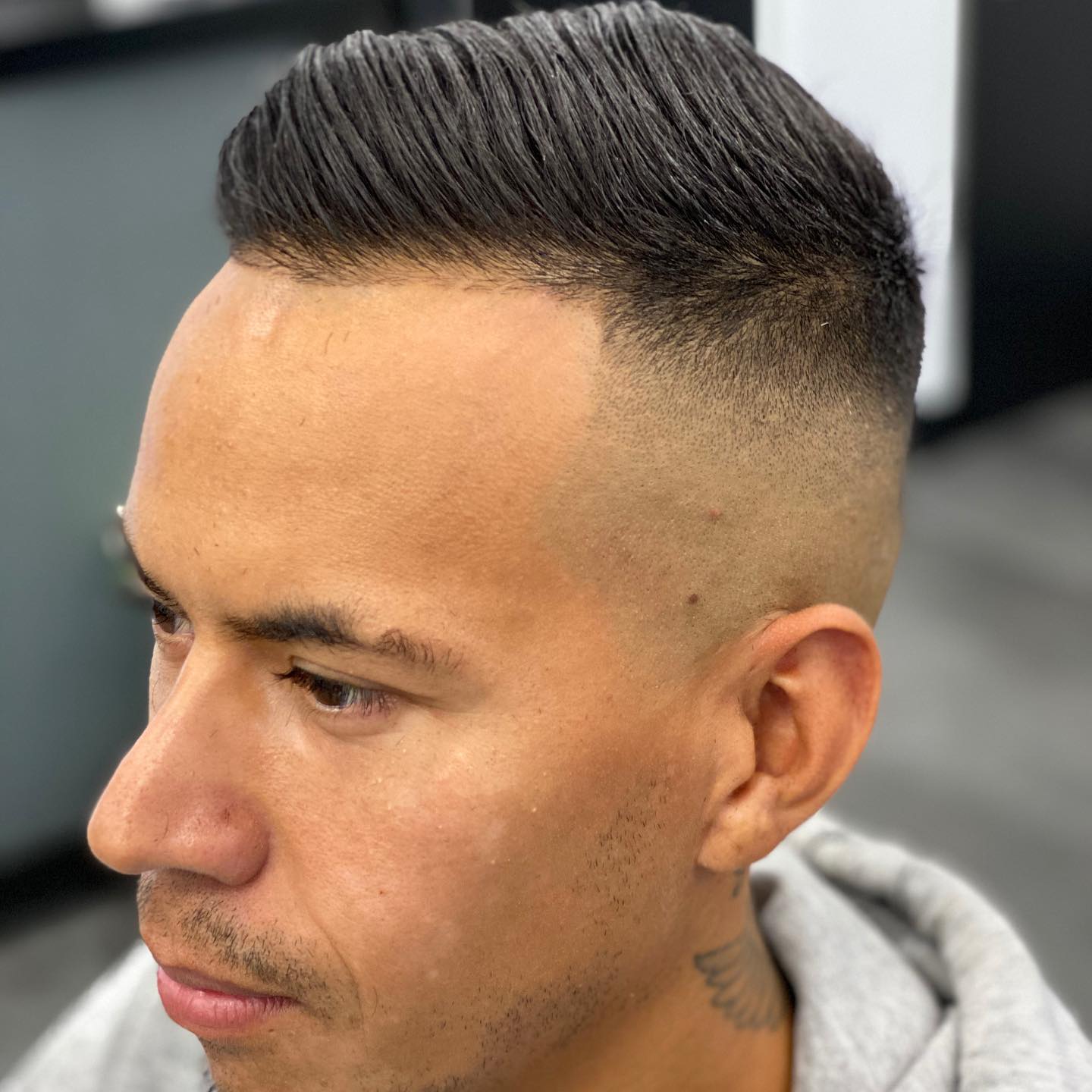 Man met een skin fade en opgestylde bovenkant, van opzij gezien