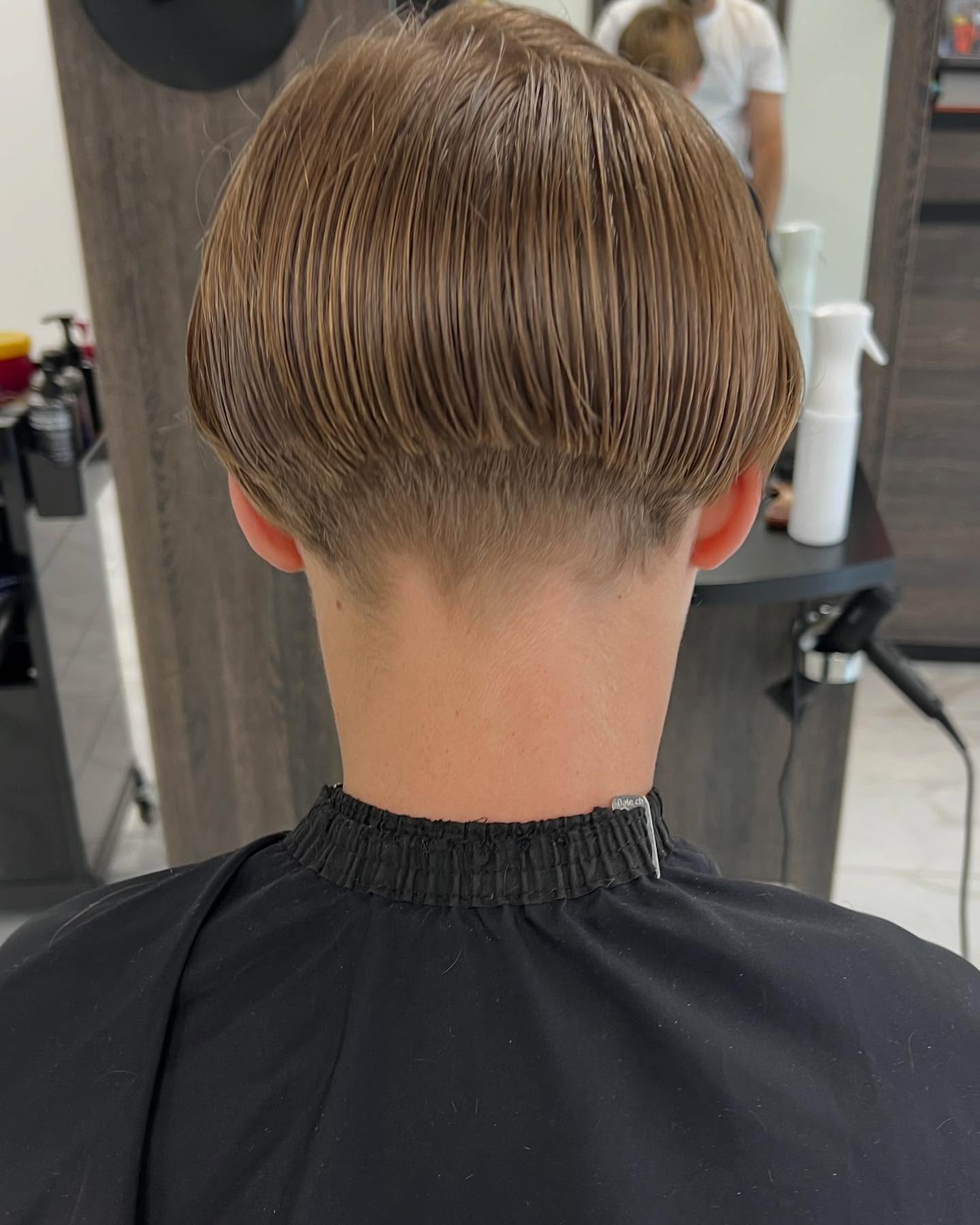 Achterhoofd met een lang gelaagd bovenhaar en een strak geknipte nek, in de salon