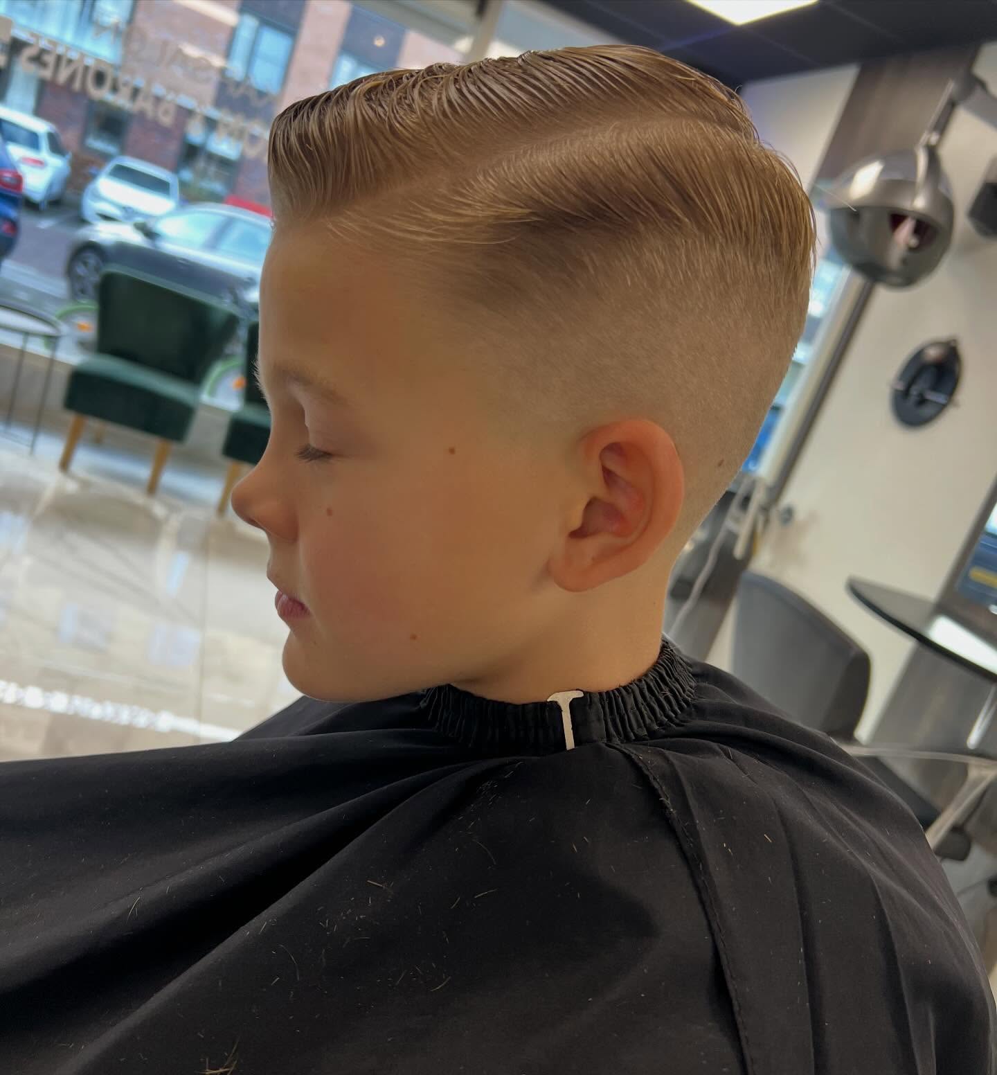 Jongen in profiel met een strak gekamde zijscheiding en fade